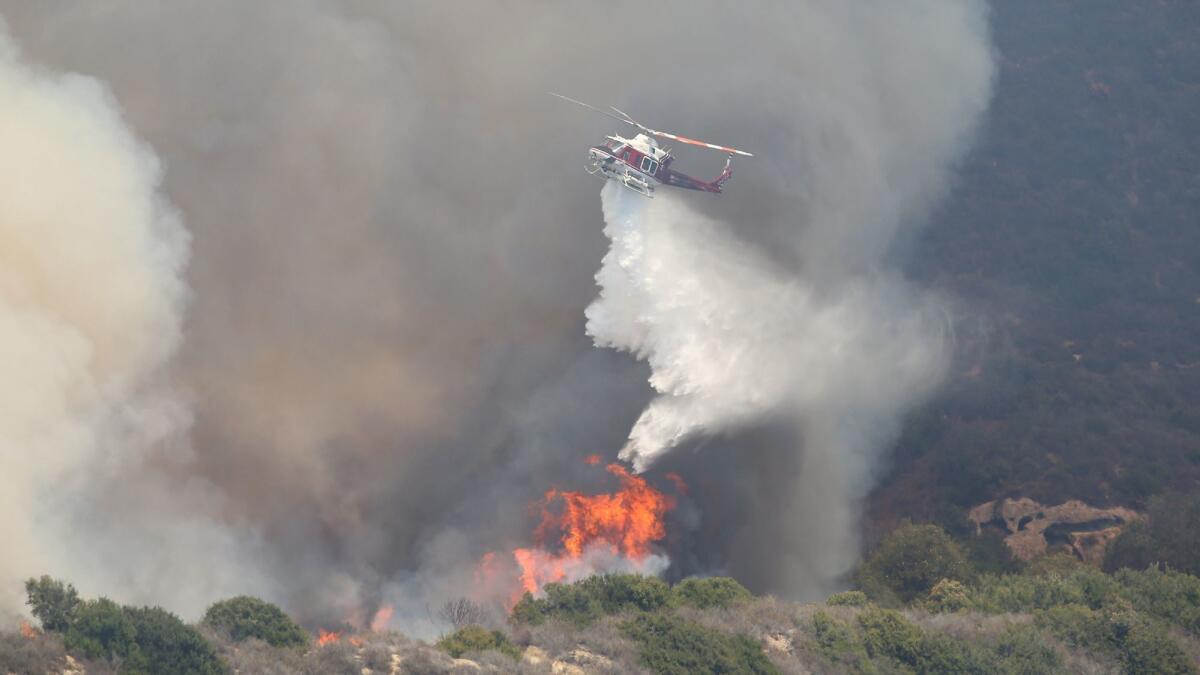 An Orange County Fire Authority helicopter makes a drop in 2018.