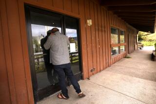 BOLINAS, CA - APRIL 25, 2024 - Bolinas resident Enzo Resta, 59, looks inside the closed post office in the rural coastal town in West Marin on April 25, 2024. "We really, really want to have this back." He has been making daily trips to Olema to pick up mail. The closure of the post office since February, 2023, is a big problem in the small town. The post office closed due to a dispute between the U.S. Postal Service and the landlord of the building where it operated. Since then, the town's 2,000 residents have had to drive to Olema or Stinson Beach, between 20 and 40 minutes round trip, to get their mail. Few people in town have the option of home delivery. (Genaro Molina/Los Angeles Times)