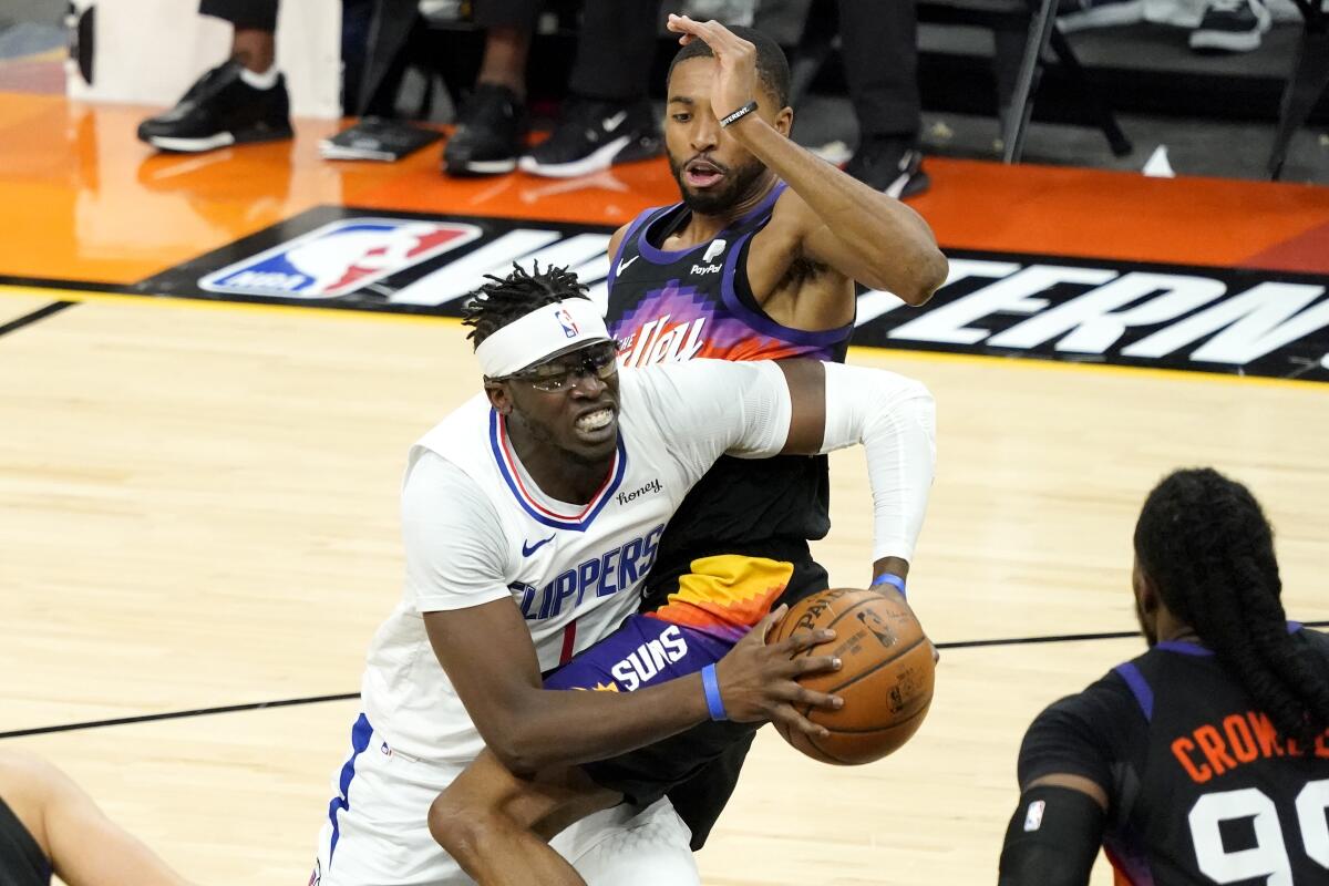 Clippers guard Reggie Jackson tries to drive past Phoenix Suns forward Mikal Bridges, right, during Game 5 on Monday.