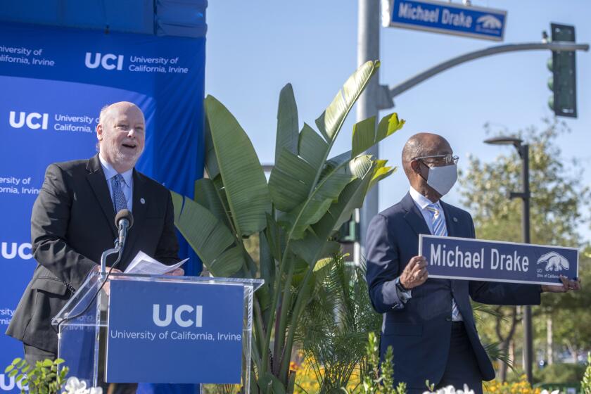 UCI Chancellor Howard Gillman, left, speaks as UC President Michael Drake, right, is presented with his named street sign at the President Drake street Dedication and Unveiling Ceremony Saturday June 4, 2021. (Photo courtesy Steve Zylius / UCI)