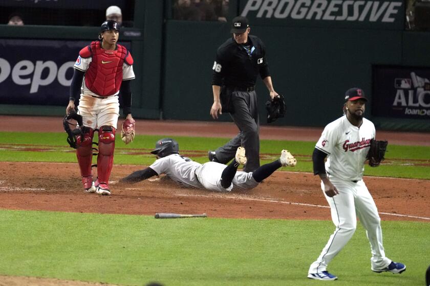 Jon Berti, de los Yankees de Nueva York, anota entre el cátcher Bo Naylor y el pitcher dominicano Emmanuel Clase, de los Guardianes de Cleveland, en el cuarto juego de la Serie de Campeonato de la Liga Americana, el viernes 18 de octubre de 2024 (AP Foto/Jeff Roberson)