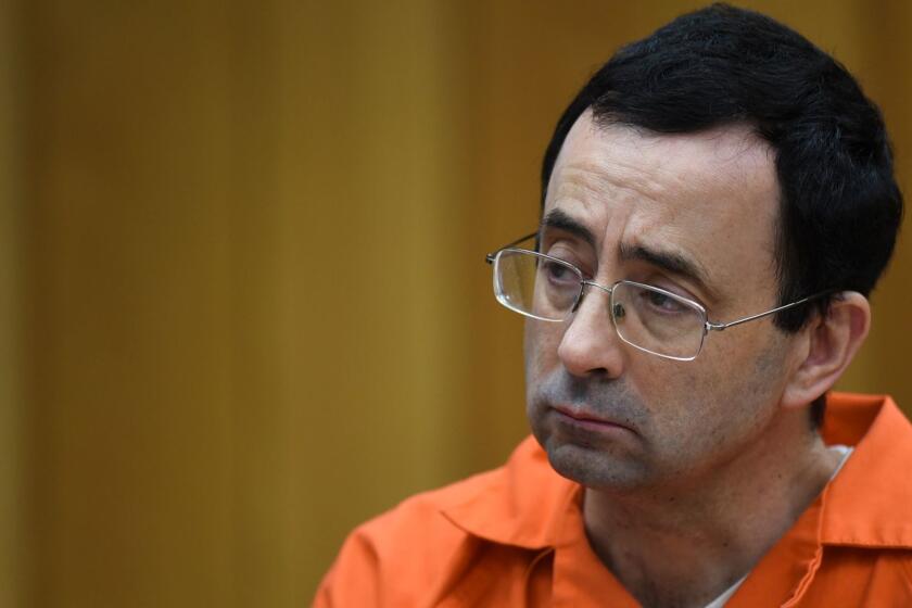 Larry Nassar listens as Rachael Denhollander gives her victim impact statement Friday, Feb. 2, 2018, in Eaton County Circuit Court, the second and final day of victim impact statements in Judge Janet Cunningham's courtroom in Charlotte, Mich. He will be sentenced Monday. (Matthew Dae Smith/Lansing State Journal via AP)