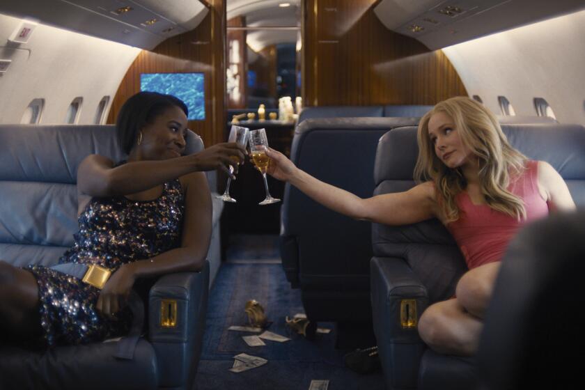 Two women make a champagne toast in private jet in the movie "Queenpins."