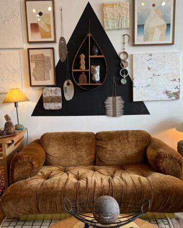 A brown sofa next to a wall adorned with art in a showroom