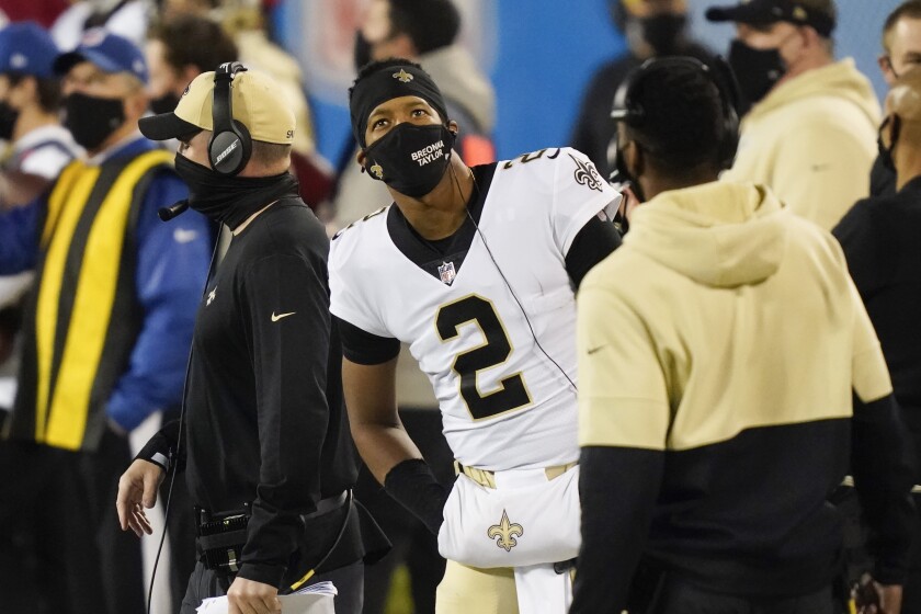 FILE -New Orleans Saints quarterback Jameis Winston wears a face mask on the sidelines against the Carolina Panthers during the first half of an NFL football game Sunday, Jan. 3, 2021, in Charlotte, N.C. U.S. sports leagues are seeing rapidly increasing COVID-19 outbreaks with dozens of players in health and safety protocols, amid an ongoing surge by the delta variant of the coronavirus and rising cases of the highly transmissible omicron mutation. (AP Photo/Gerry Broome, File)