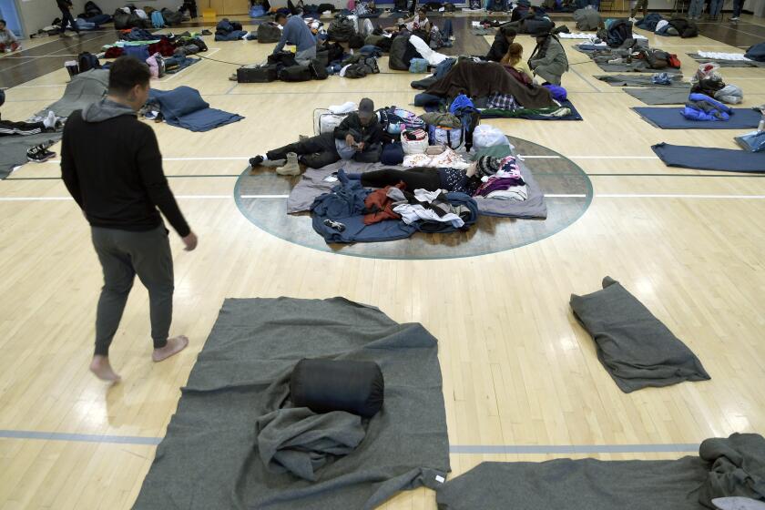 ARCHIVO - Migrantes descansan en un refugio improvisado, el 6 de enero de 2023, en Denver. (AP Foto/Thomas Peipert, Archivo)