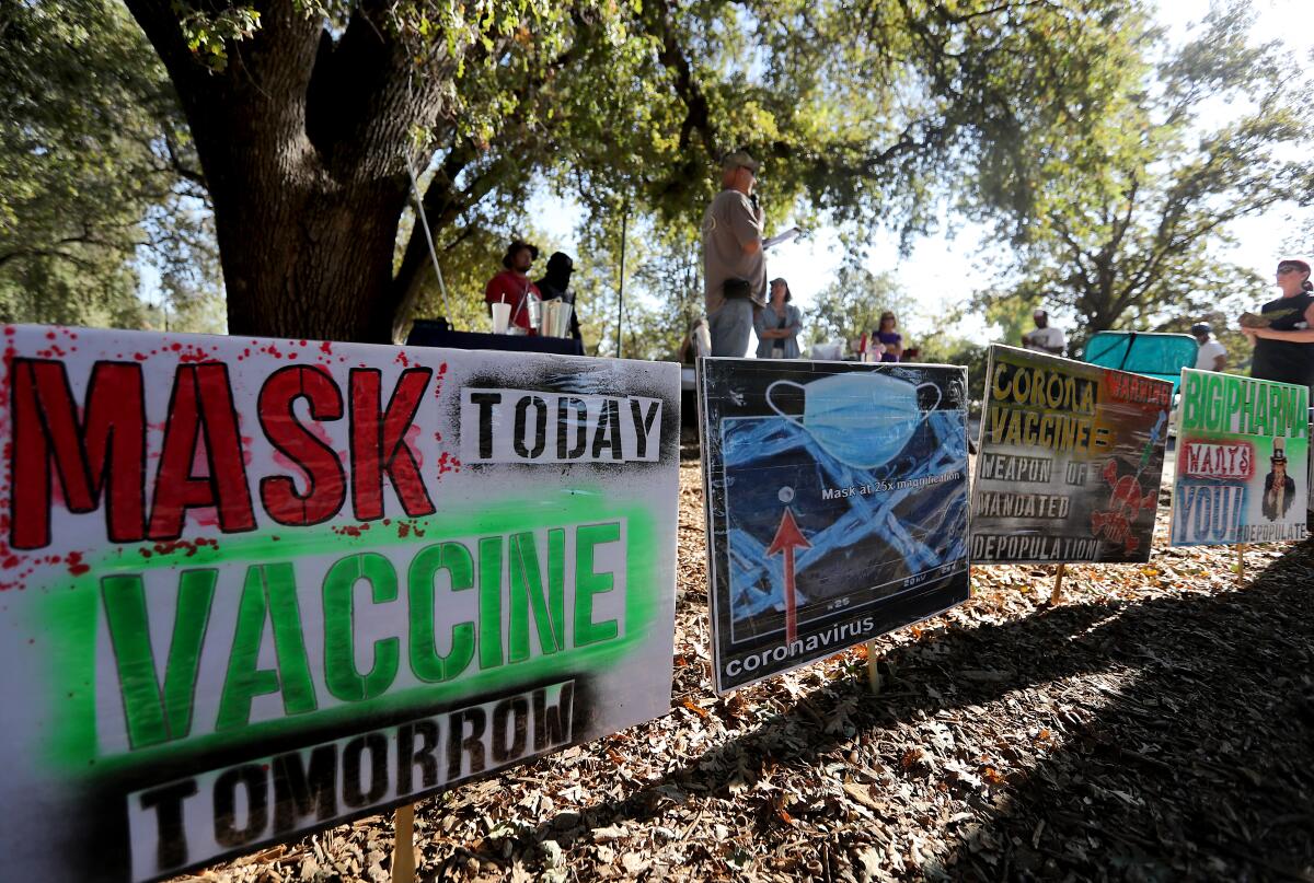 A row of signs about masks and vaccines