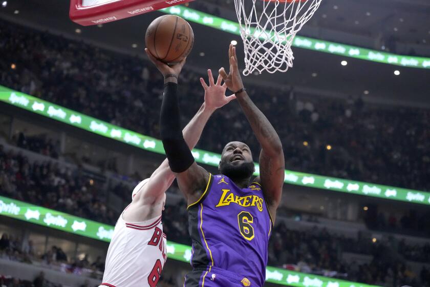 Los Angeles Lakers' LeBron James drives to the basket as Chicago Bulls' Alex Caruso defends during the first half of an NBA basketball game, Wednesday, March 29, 2023, in Chicago. (AP Photo/Charles Rex Arbogast)