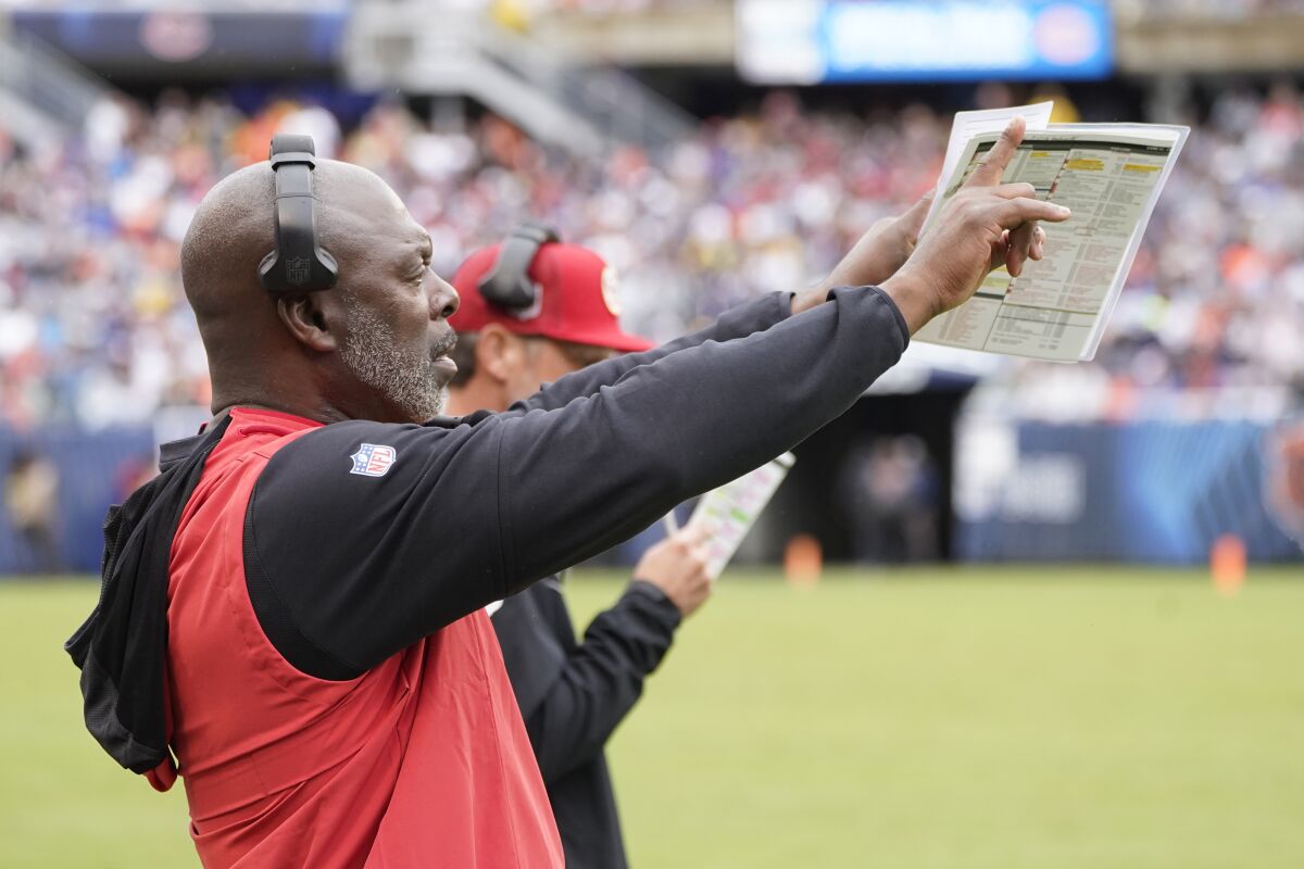 San Francisco 49ers assistant head coach Anthony Lynn signals his players from the sideline.