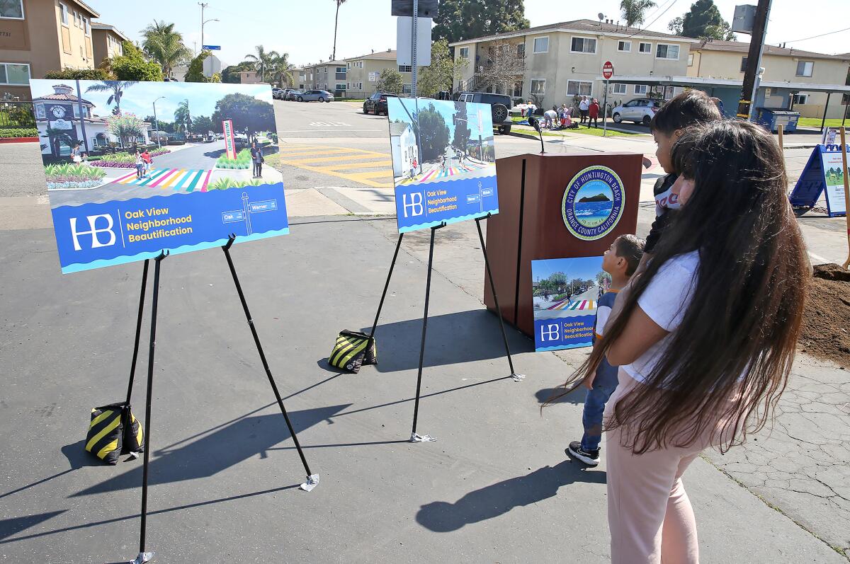 Resident Elia Hernandez looks at posters of the Oak View Beautification Project.