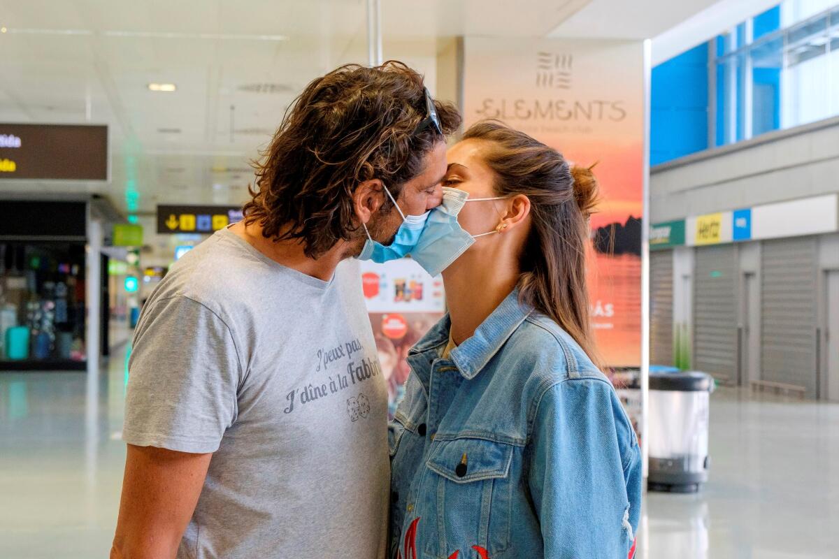 Una pareja de turistas alemanes se besa tras aterrizar de su vuelo 