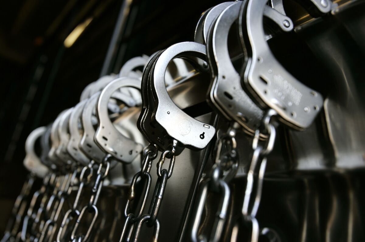 Handcuffs line a wall at a detention area