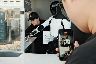 Tesla robot Optimus serves popcorn to guests at the Tesla Diner on the restaurant's opening day on July 21.