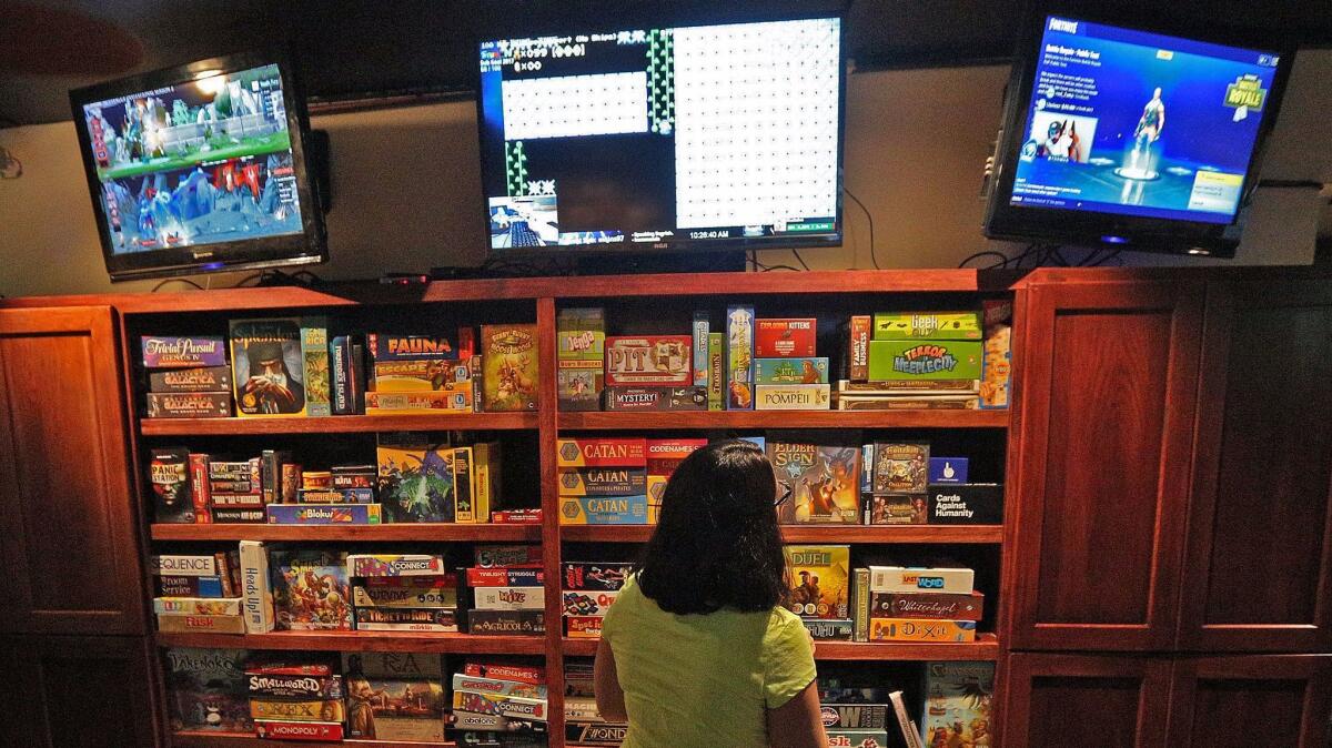 Kayla Campato, of Bakersfield, considers game options at Guild Hall in Burbank on Thursday, September 14, 2017. Guild Hall is Burbank's first esports bar, where various live video-game play is streamed instead of conventional sports.