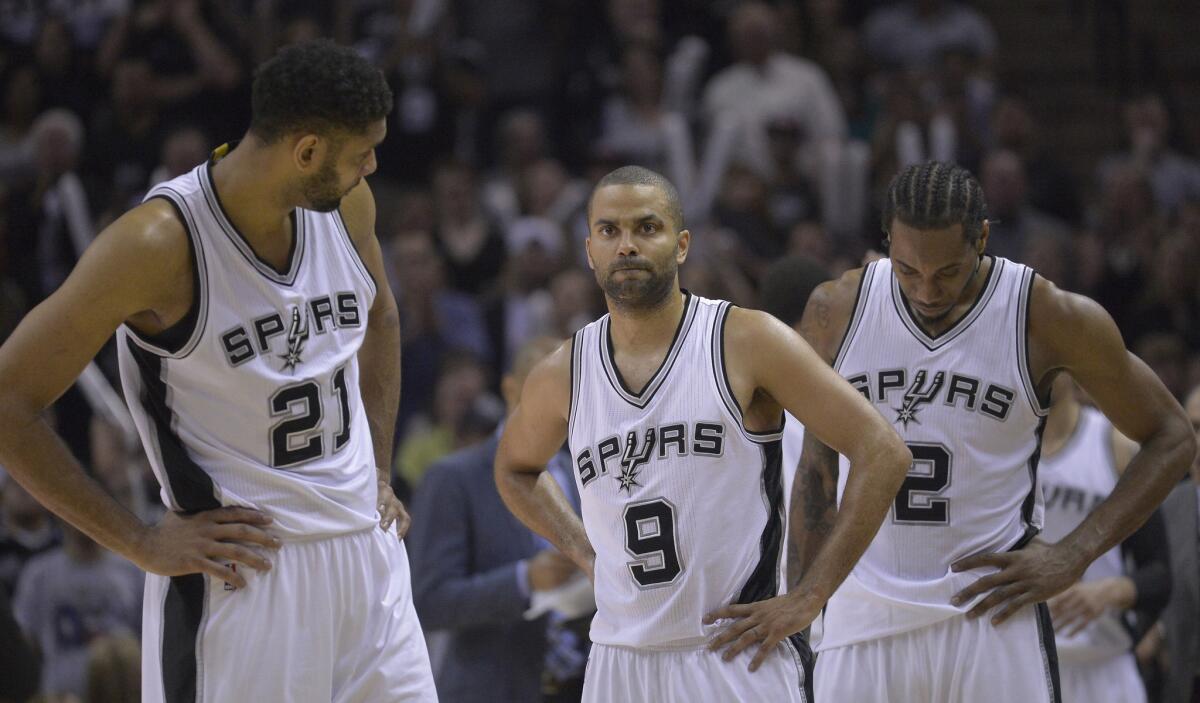 The Spurs' Tim Duncan, Tony Parker and Kawhi Leonard await the resumption of play during a playoff game against the Clippers in San Antonio on April 30, 2015.