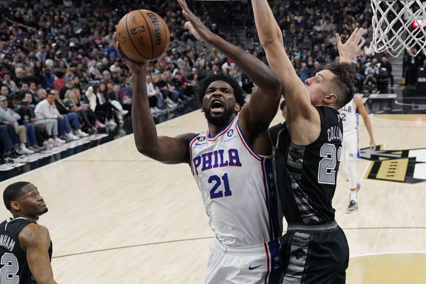Philadelphia 76ers center Joel Embiid (21) is fouled as he drives to the basket against San Antonio Spurs forward Zach Collins (23) during the first half of an NBA basketball game in San Antonio, Friday, Feb. 3, 2023. (AP Photo/Eric Gay)