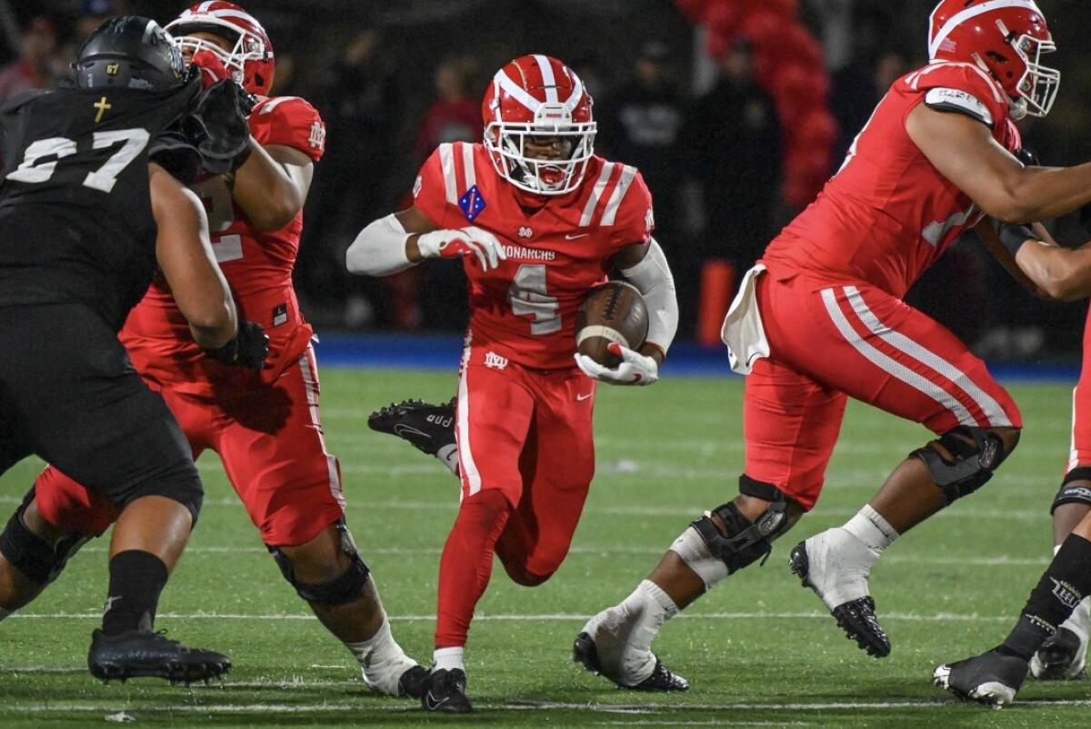 Raleek Brown of Mater Dei finds an opening in the Servite line on a run.