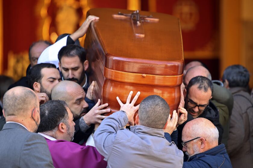 The coffin of the church sacristan who was attacked and killed Wednesday is carried out of a church after a funeral mass in Algeciras, Spain, Friday, Jan. 27, 2023. Spanish police have raided the home of a 25-year-old Moroccan man held over the machete attacks at two Catholic churches that left a church officer dead and a priest injured in the southern city of Algeciras. A National Court judge is investigating the incident as a possible act of terrorism. (AP Photo/Juan Carlos Toro)