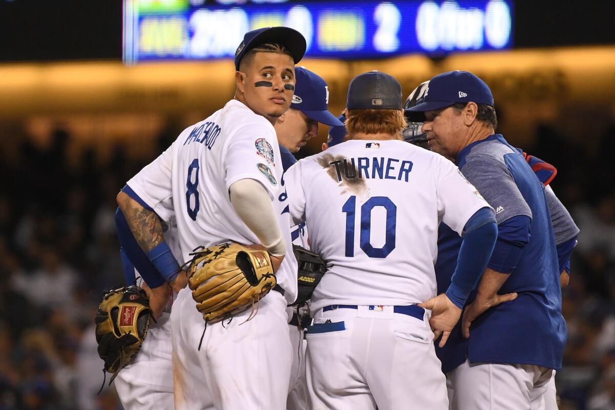 Manny Machado #8 of the Los Angeles Dodgers reacts on the mound against the Milwaukee Brewers during the eighth inning in Game Three of the National League Championship Series at Dodger Stadium on October 15, 2018 in Los Angeles, California.