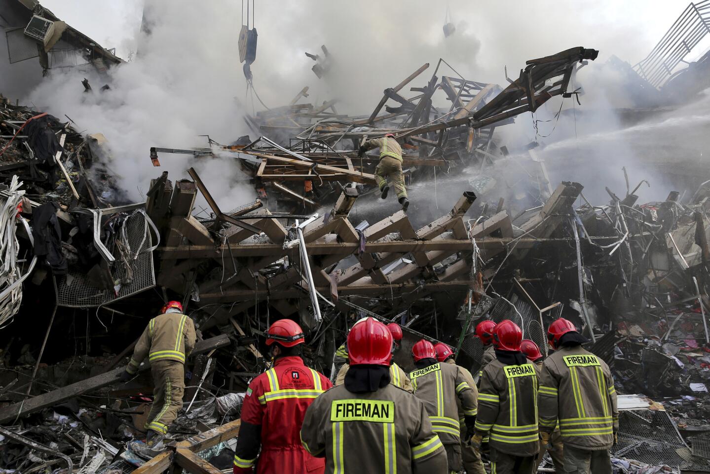 Iranian firefighters remove debris of the Plasco building, which was engulfed by a fire and collapsed in central Tehran.