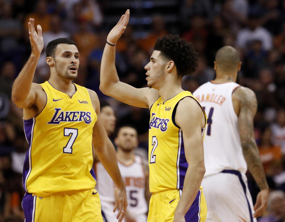 Lakers guard Lonzo Ball (2) and forward Larry Nance Jr. (7) had plenty to celebrate near the end of their game against the Suns on Oct. 20.
