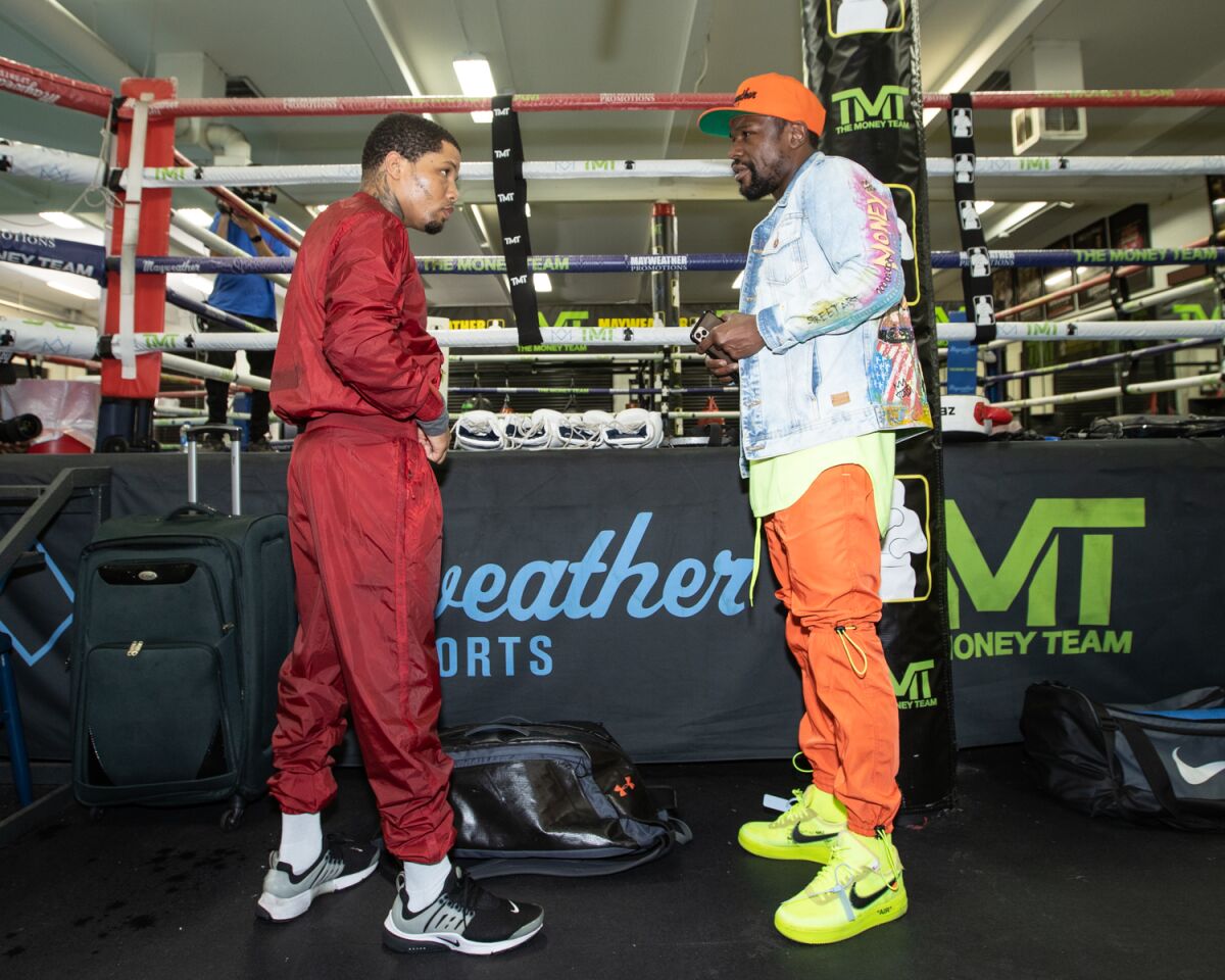 Gervonta Davis, left, and boxing great Floyd Mayweather Jr. speak during a training session in October 2020.