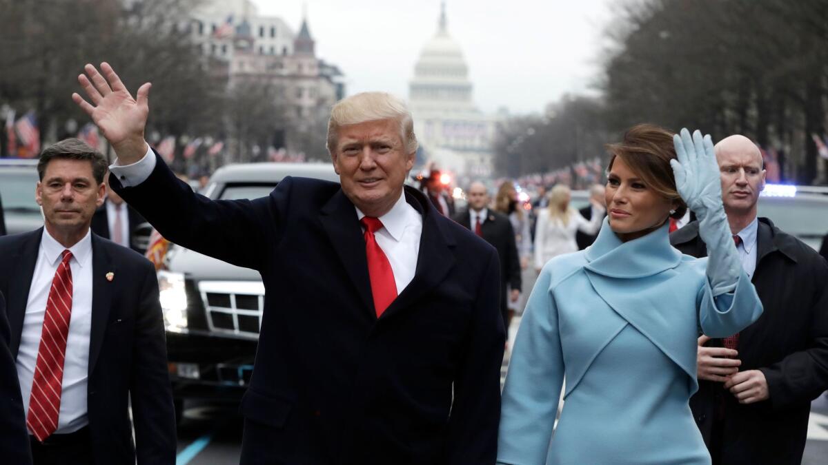 President Donald Trump waves as he walks with first lady Melania Trump during the inauguration parade on Pennsylvania Avenue in Washington on Jan. 20.