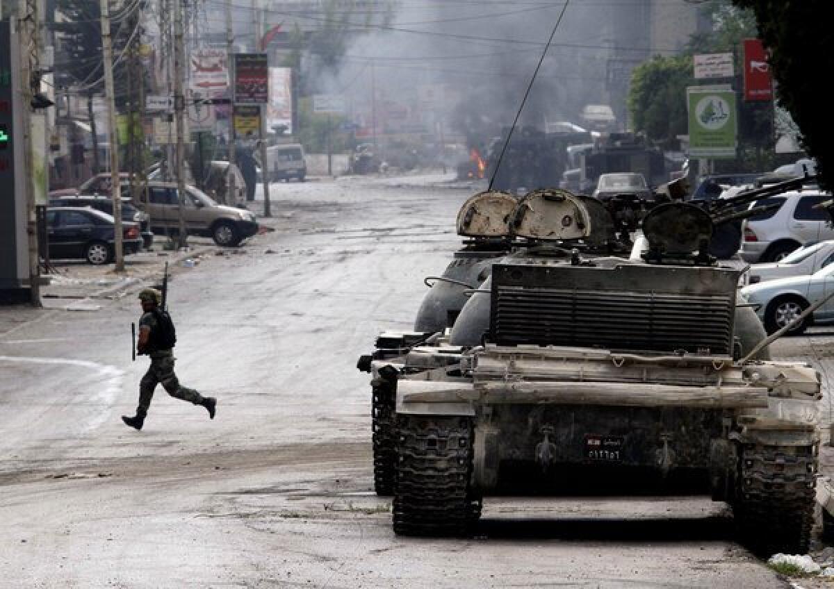 A Lebanese soldier runs across a street during clashes in the southern port city of Sidon.