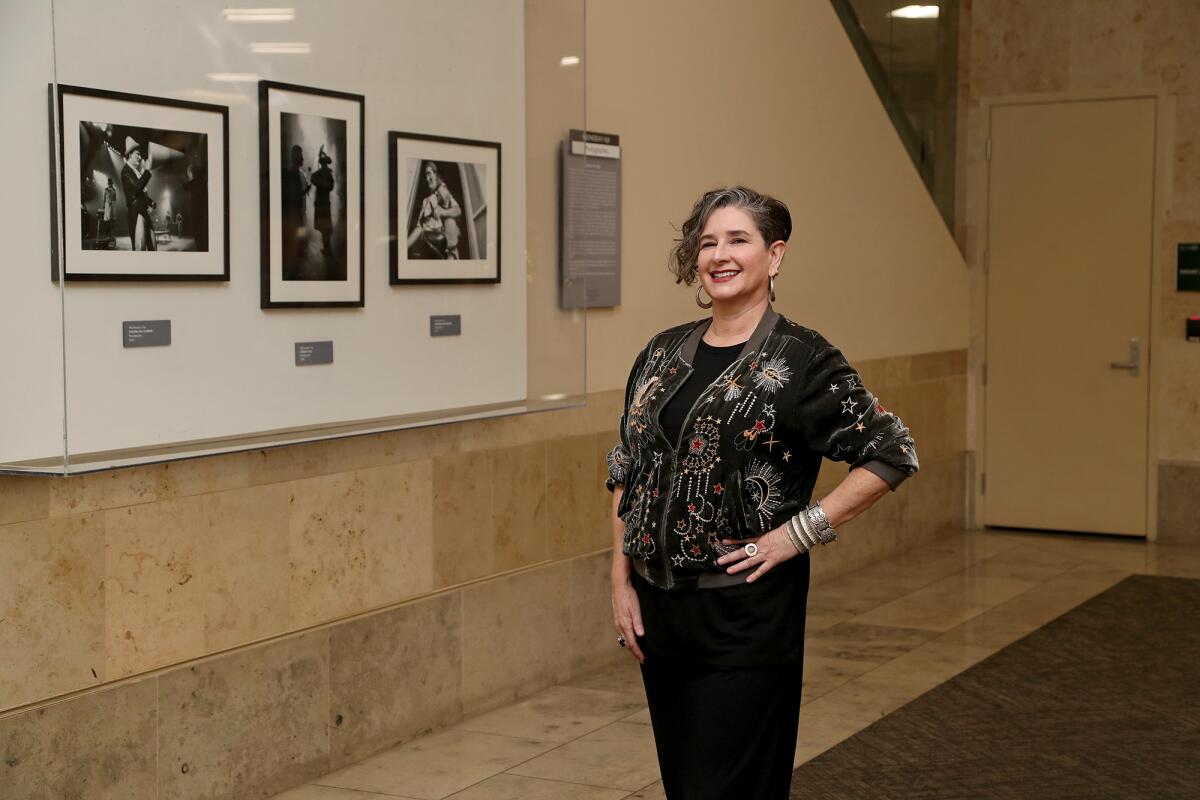 Wednesday Aja stands next to a set of her photographs located at the Riley Terminal at John Wayne Airport. 