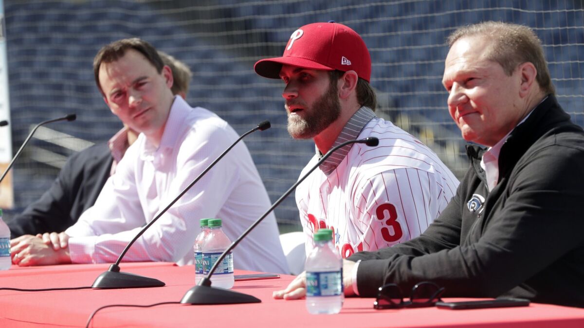 Bryce Harper, second from right, speaks as agent Scott Boras, right, looks on during a news conference at the Phillies spring training baseball facility on Saturday in Clearwater, Fla.