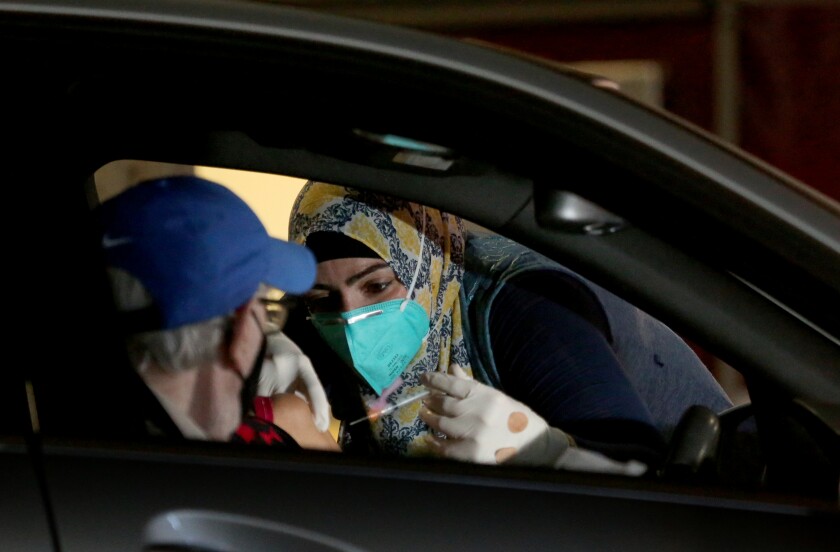Dr. Sarah Mohtadi administers COVID-19 vaccine at a drive-in vaccination site at the Long Beach Convention Center