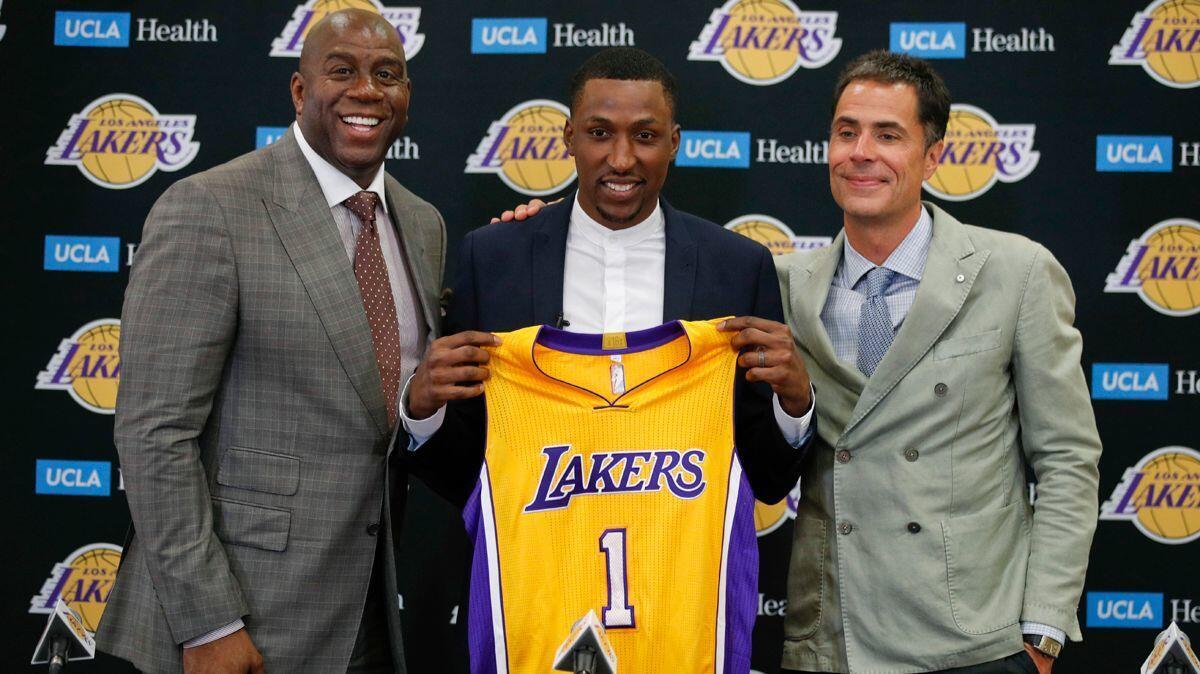 Lakers' Kentavious Caldwell-Pope, center, poses for photos with Magic Johnson, left, and general manager Rob Pelinka during a news conference Tuesday.