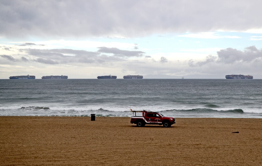 Cargo ships can be seen anchored off the coast of Huntington Beach.
