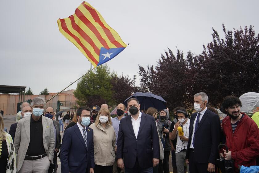 FILE - Former deputy president of the Catalan regional government Oriol Junqueras, centre, walks with the current Catalonian president Pere Aragones, 2nd left, in front of an "estelada" or Catalan pro-independence flag after being released from the Lledoners prison in Sant Joan de Vilatorrada near Barcelona, Spain, June 23, 2021. The phones of dozens of pro-independence supporters in Spain's northeastern Catalonia, including the regional chief and other elected officials, were hacked with controversial spyware available only to governments, a cybersecurity rights nonprofit said Monday April 18, 2022. (AP Photo/Joan Mateu, File)