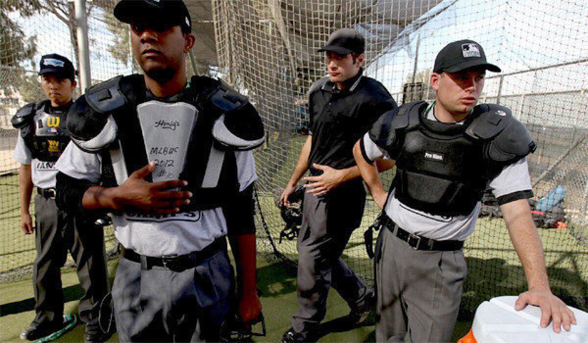 Baseball umpire trainees prepare to learn the basics of calling balls and strikes in a batting cage at Compton Community College in Compton on Nov. 7.