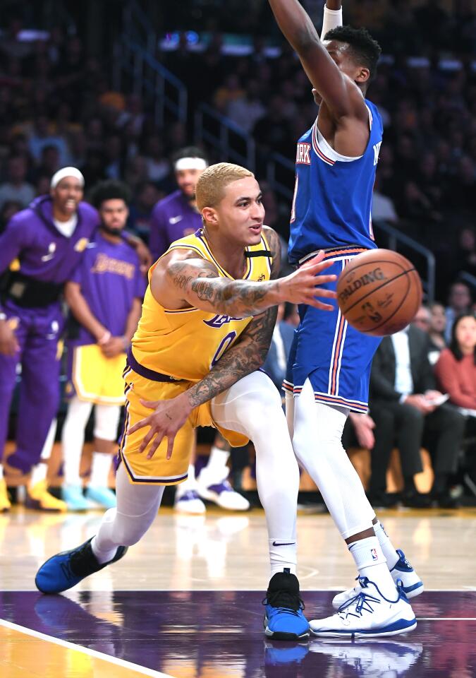 Lakers forward Kyle Kuzma tries to throw a pass while being defended by Knicks guard Frank Ntilikina during the second quarter of a game Jan. 7 at Staples Center.