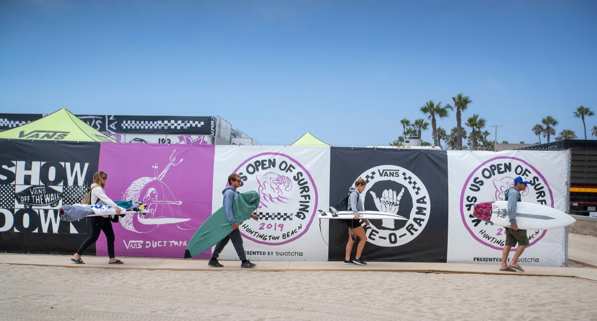 Surfers exit the contest area after a day of competition at the US Open of Surfing in Huntington Beach in 2019.