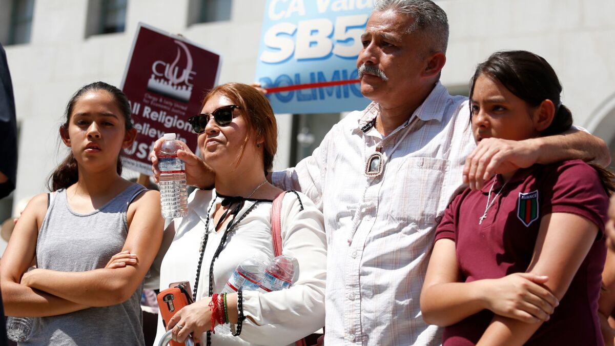 Romulo Avelica Gonzalez, an immigrant in the country illegally, and his family held a news conference in downtown Los Angeles on Thursday. Six months ago, he was arrested while taking his daughters to school in Lincoln Heights.