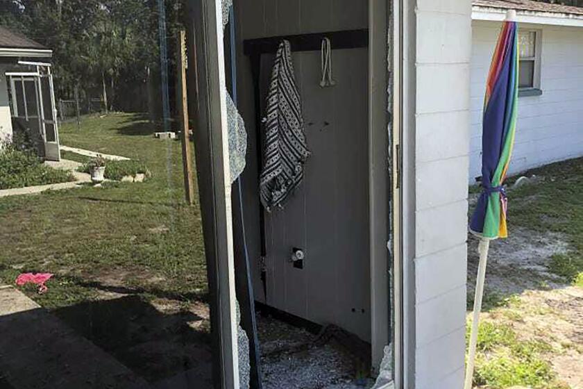 This image provided by the Polk County Sheriff's Office shows the back of the residence where a Polk sheriff's lieutenant entered the house and exchanged fire with a shooting suspect in a neighborhood in Lakeland, Fla. Four people are dead including a mother who was still cradling her now-deceased baby in what Florida sheriff's deputies are calling a massive gunfight early Sunday with a suspect they said was “ready for battle.” (Polk County Sheriff's Office via AP)