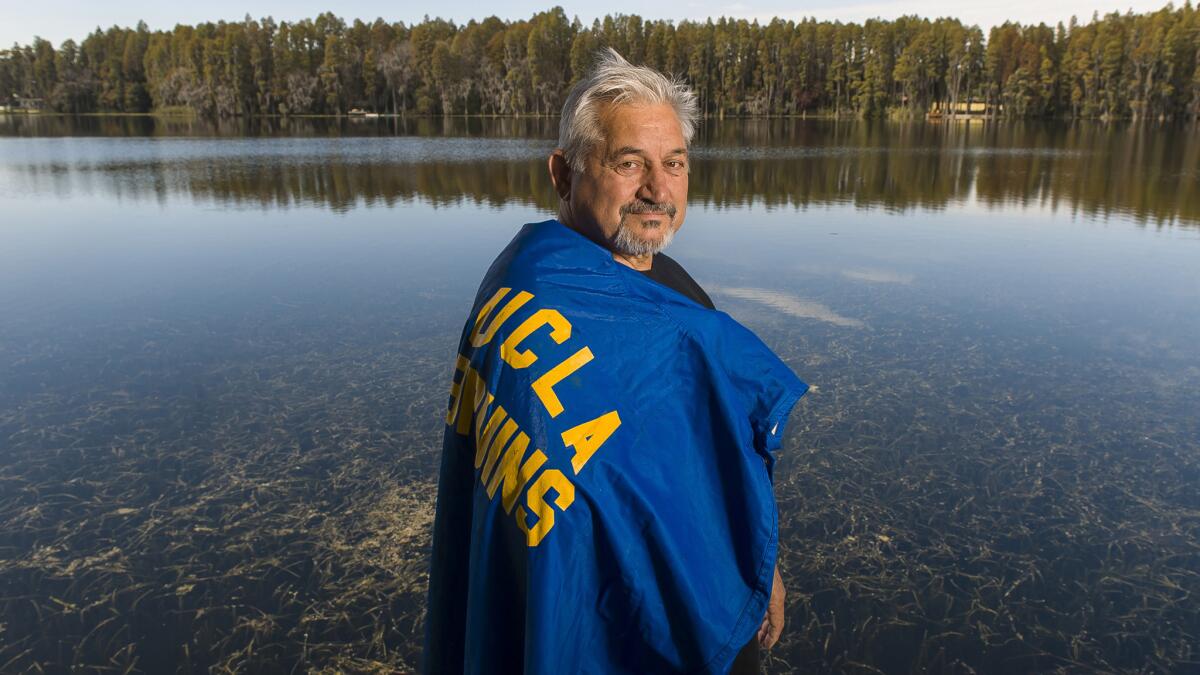 Zenon Andrusyshyn dons his UCLA football raincoat, at his home in Land O' Lakes, Fla. The son of Ukrainian parents, Andrusyshyn was born in a German refugee camp and migrated with his family to Canada when he was 3 years old.