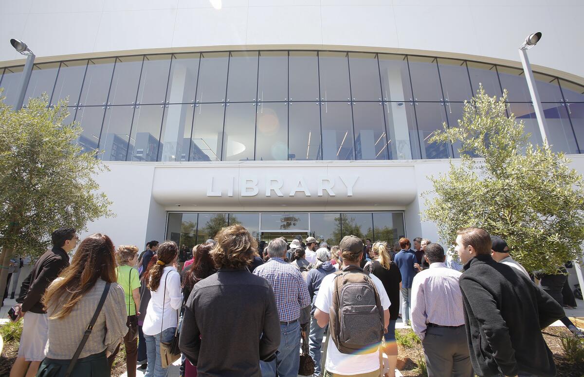 Guests walk into the new Donald Dungan Library at Lions Park during its grand opening in May.