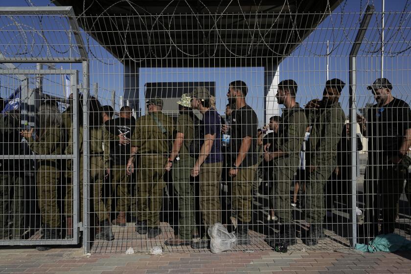 FILE - Israeli soldiers gather at the gate to the Sde Teiman military base, as people protest in support of soldiers being questioned for detainee abuse, July 29, 2024. (AP Photo/Tsafrir Abayov, File)