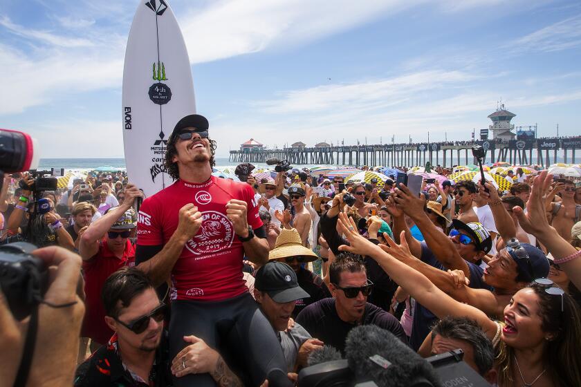 Fans cheer the U.S. Open of Surfing men's title in Huntington Beach on Sunday.