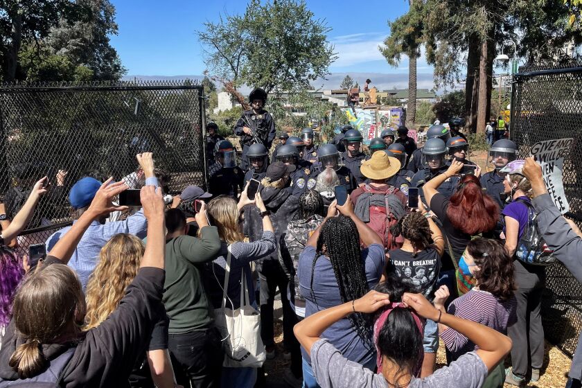 BERKELEY CA AUGUST 3, 2022 - Protesters confront officers as they try to break through fence into People's Park in Berkeley, Wednesday August 3, 2022. The park has been fenced off and closed as UC Berkeley will build student housing on the site. (Stuart Leavenworth / Los Angeles Times)