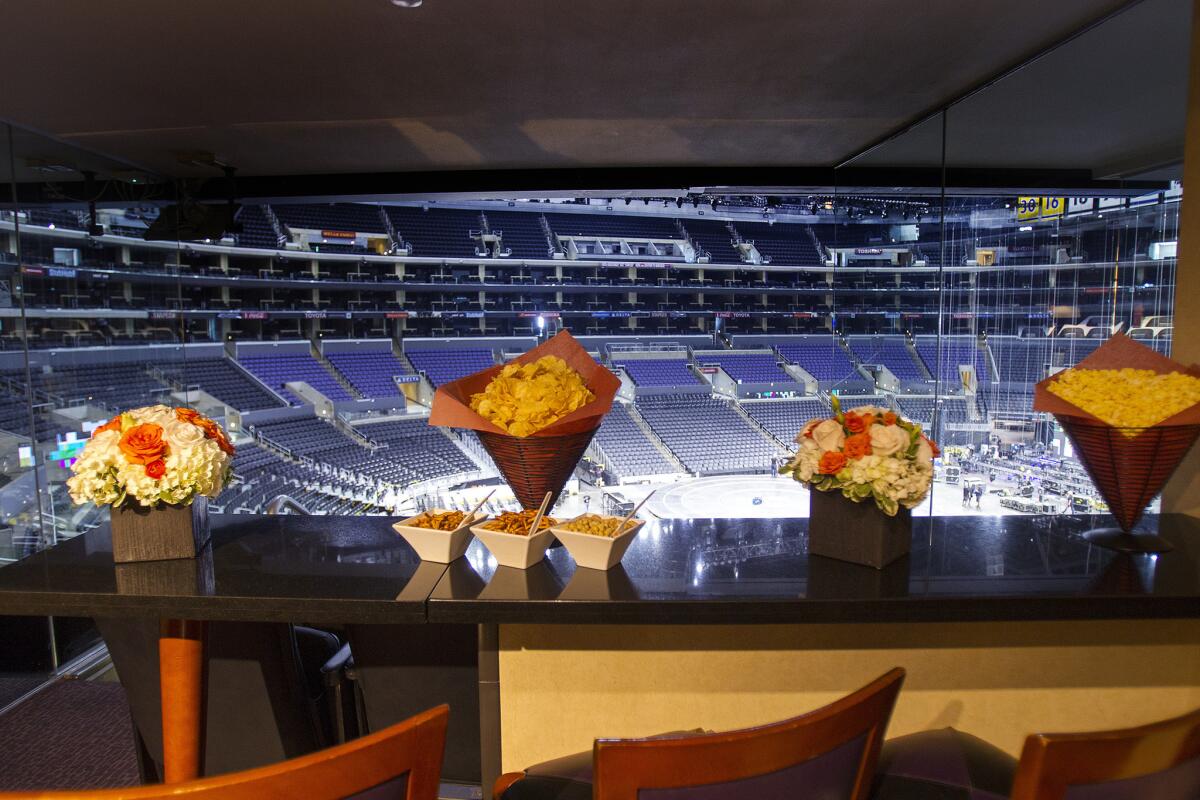 Flower bouquets and munchies in cones are ready for spectatorss inside a luxury suite at Staples Center.