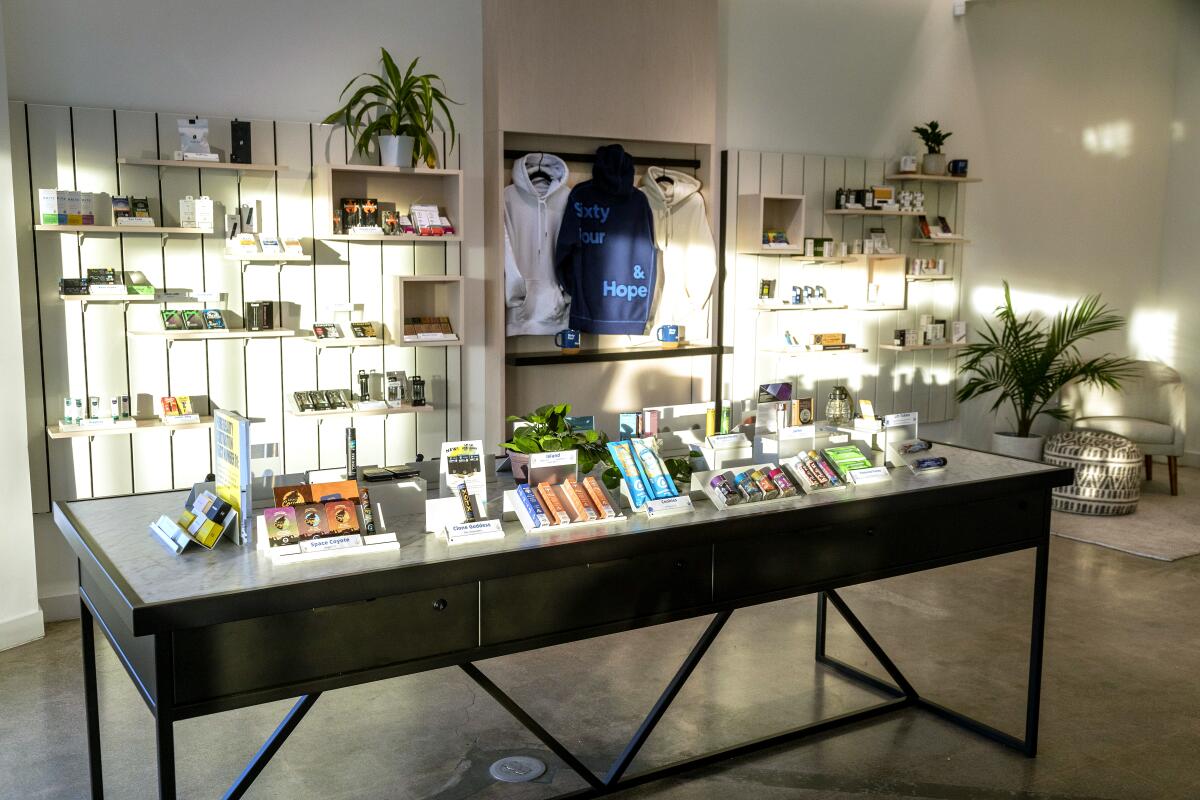 A table framed with plants and filled with cannabis products at the Sixty Four & Hope dispensary 