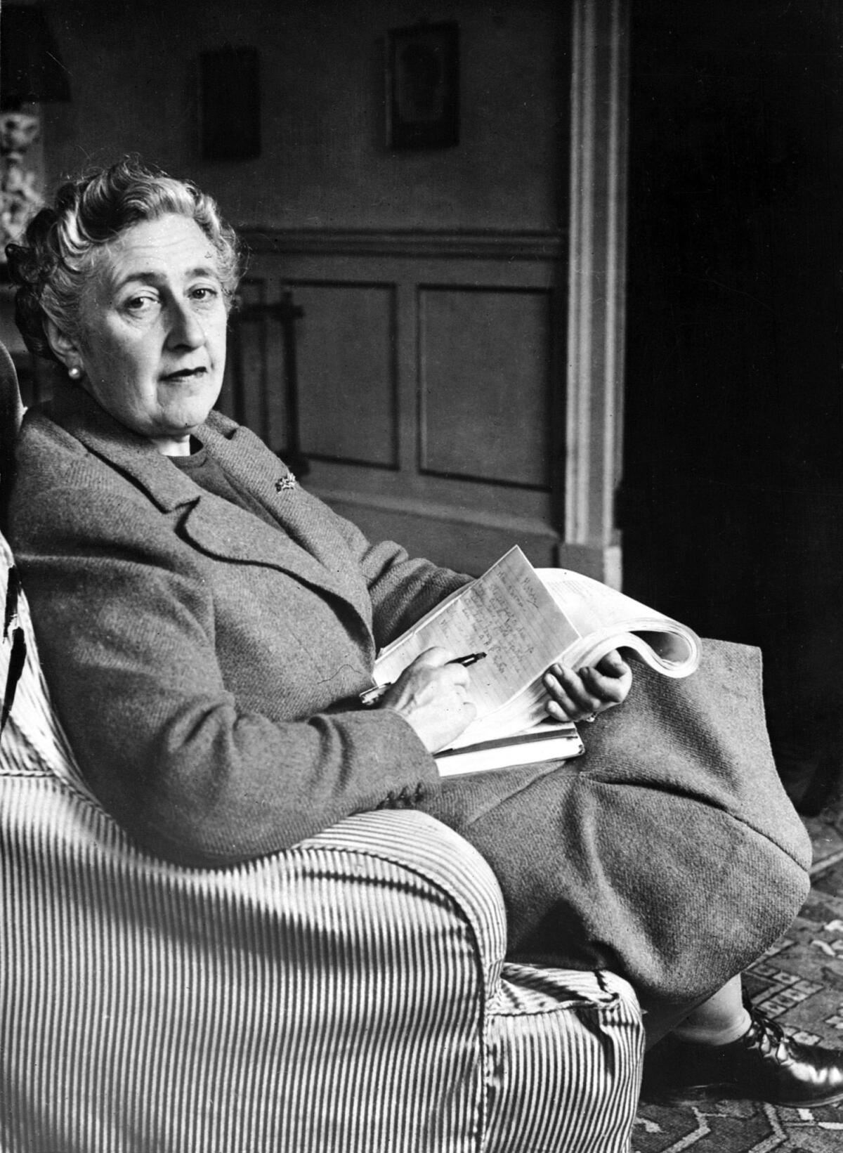 English writer Dame Agatha Christie, poses in March 1946 for a photographer holding a notebook, in her home, Greenway House, in Devonshire. Agatha Christie, born Miller (1890-1976) in Torquay, Devon, wrote, under the surname of her fist husband Colonel Archibald Christie (divorced in 1928) more than 70 detective novels featuring the Belgian detective, Hercule Poirot, or the inquiring village lady, Miss Marple. In 1930, Christie married Max E. L. Mallowan (1904-1978; knighted in 1968), professor of archaeology at London University (1947-78), with whom she travelled on several expeditions. Several of her stories have become popular films, such as "Murder on the Orient Express" (1974) and "Death on the Nile (1978). Christie was made a dame in 1971. (Photo credit should read -/AFP/Getty Images)