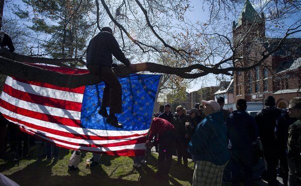 Supporters hang an American flag in a tree across the street from St. Joseph's Church before the start of the funeral for bombing victim Krystle Campbell in Medford, Mass.