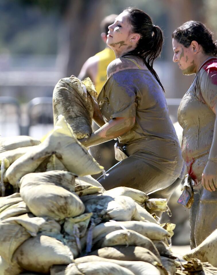 A participant lifts a heavy sand bag at one station of the Gladiator Rock 'n Run.