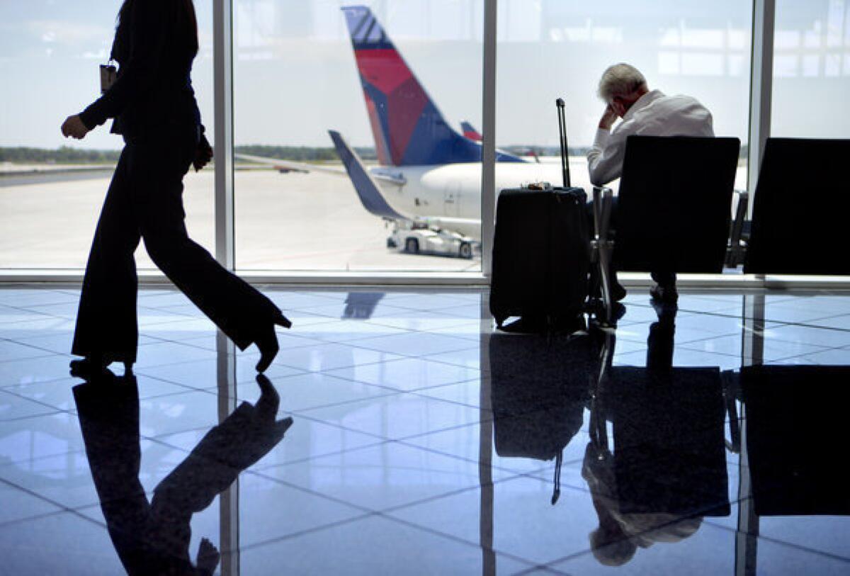 A passenger sits in the international terminal at Hartsfield-Jackson airport in Atlanta.